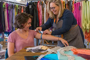 designer measuring customer for custom made gloves